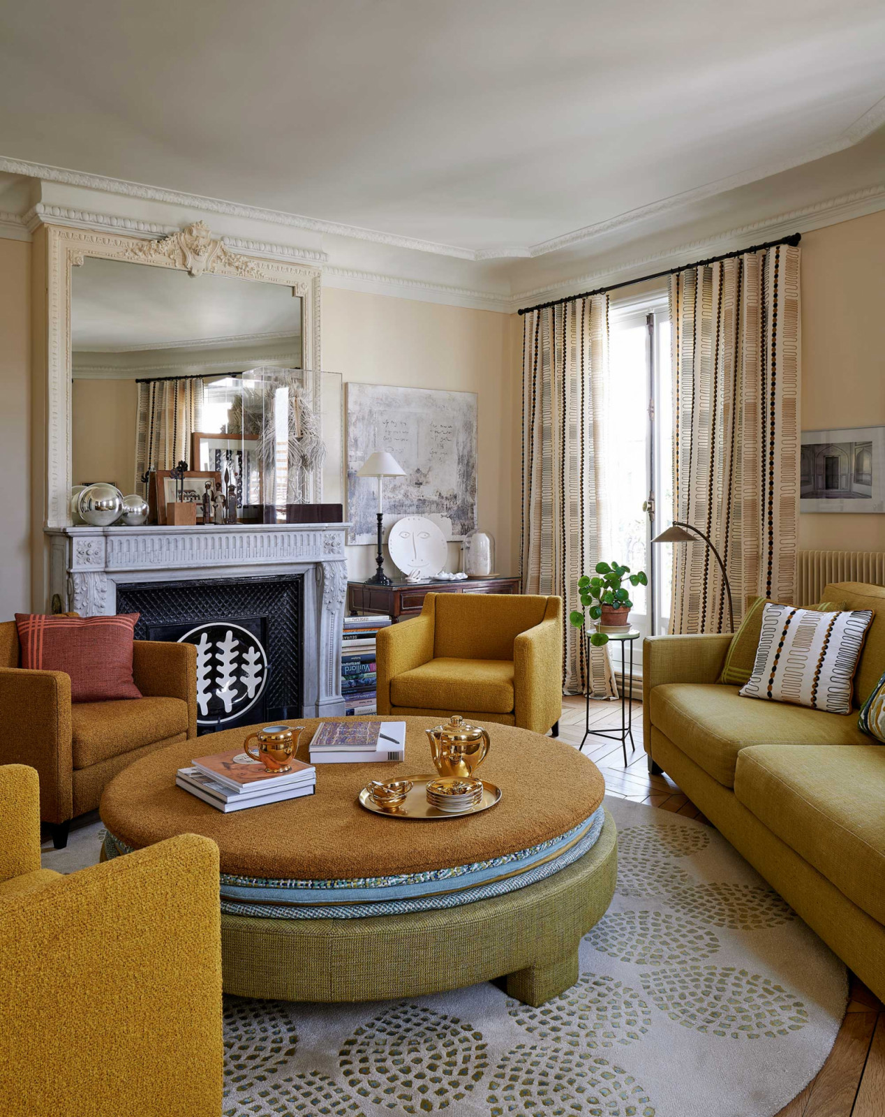 The living room, where the sofa, armchairs, coffee table and rug are all by Pierre Frey, curtains in Funambule embroidery, and miniature sculptures by Sandrine Courau on the Louis XVI marble fireplace