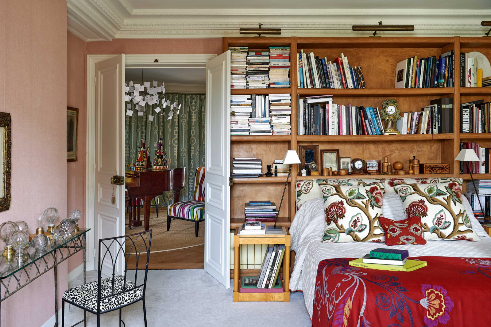 The bedroom, clad in Pierre Frey’s aged linen Craft, with bookshelves by Savinel and Le Bévillon
