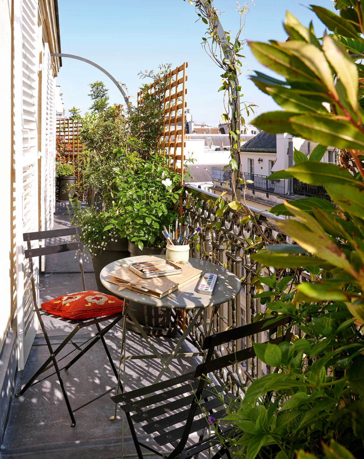 The landscaped balcony by Horticulture et Jardins, where Lorraine’s watercolours wait on the table above Parisian rooftops