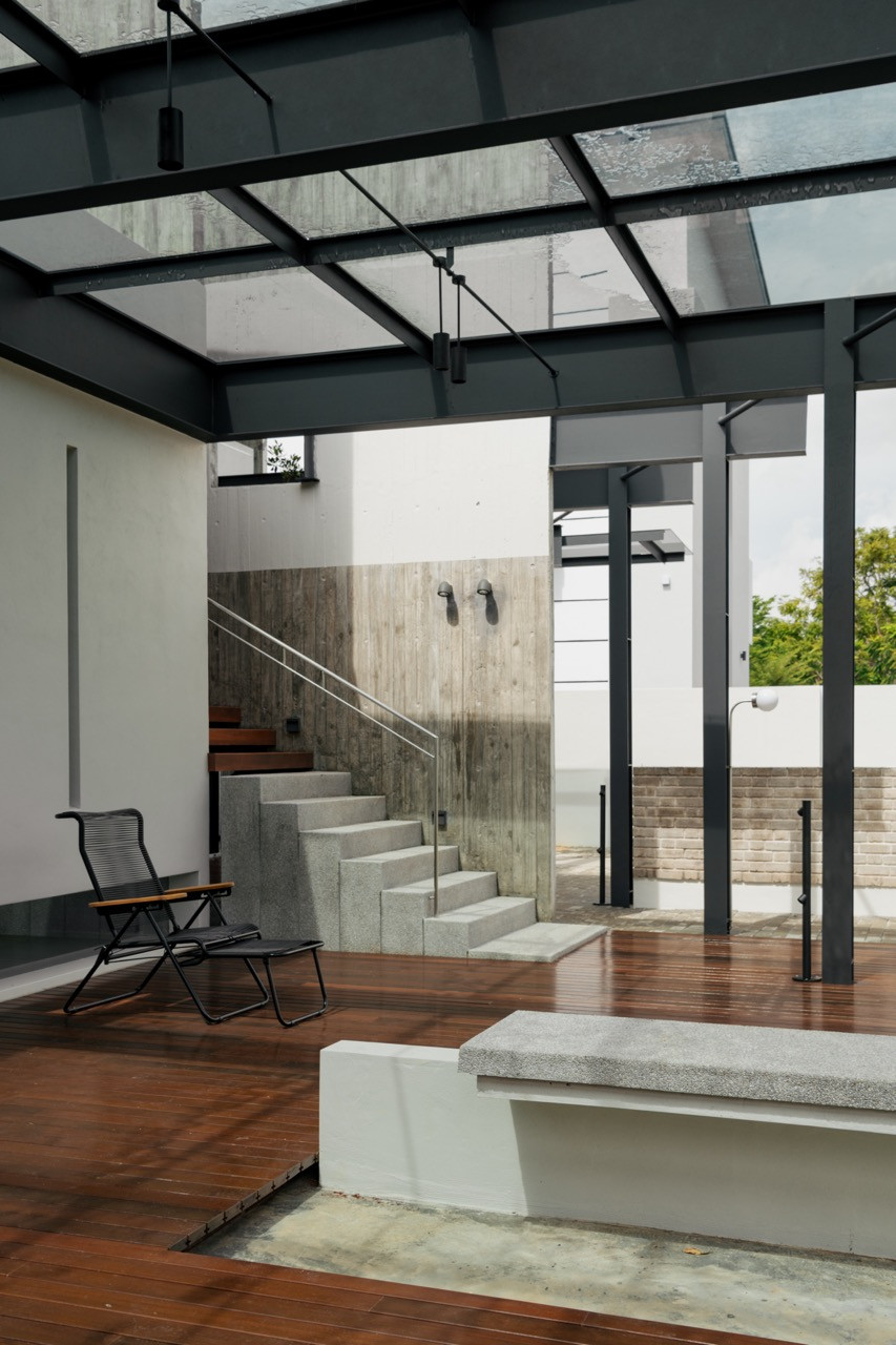 A sheltered corner of the deck, furnished simply with a single folding chair beside a concrete bench