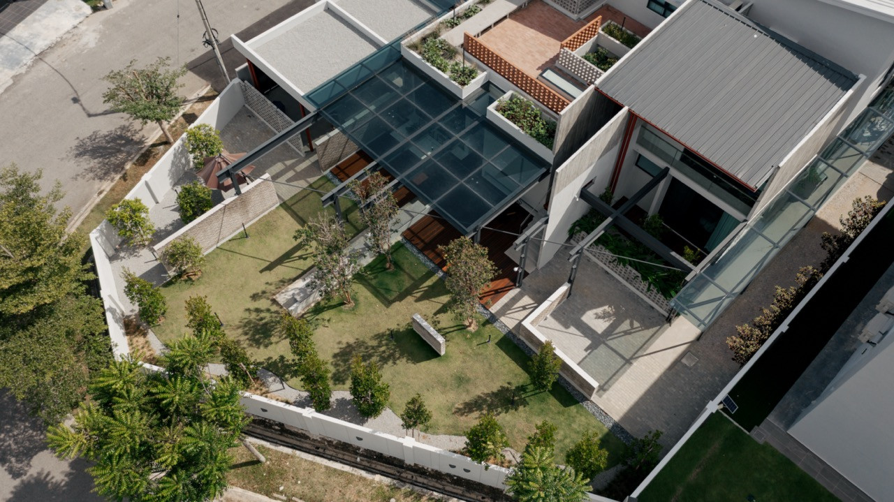 An aerial view of the property, showing the glass-roofed deck, rear lawn and layered concrete rooflines