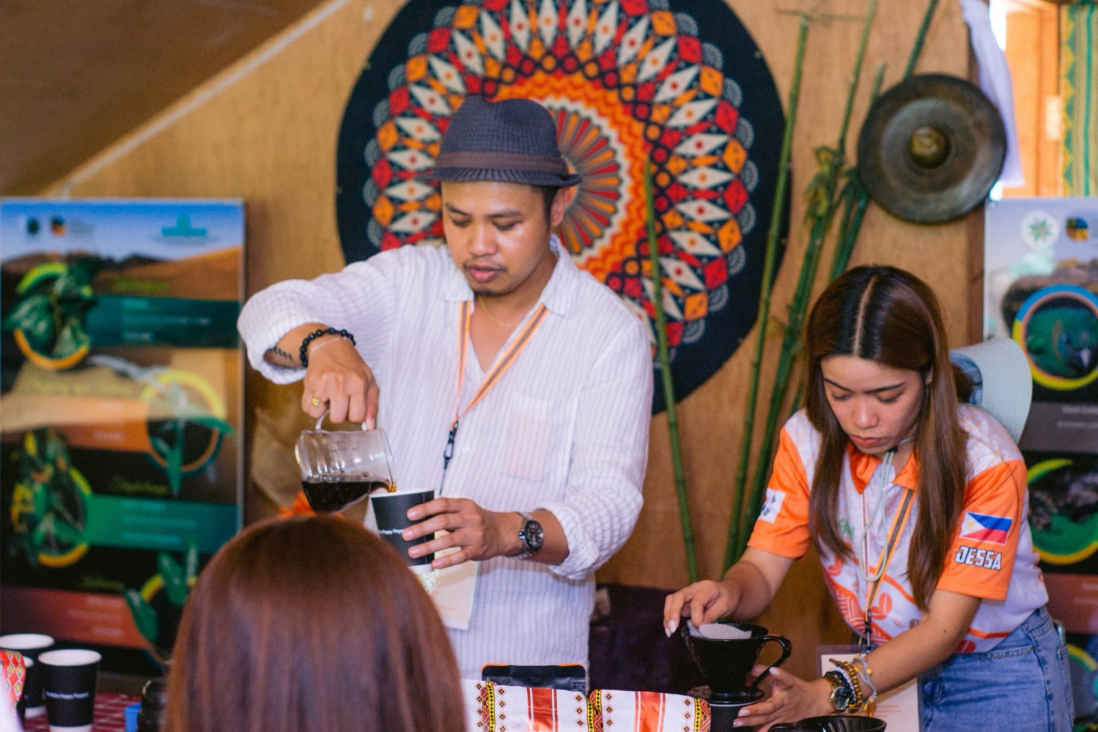 Baristas showcase pour-over coffee brewing at a specialty coffee event.
