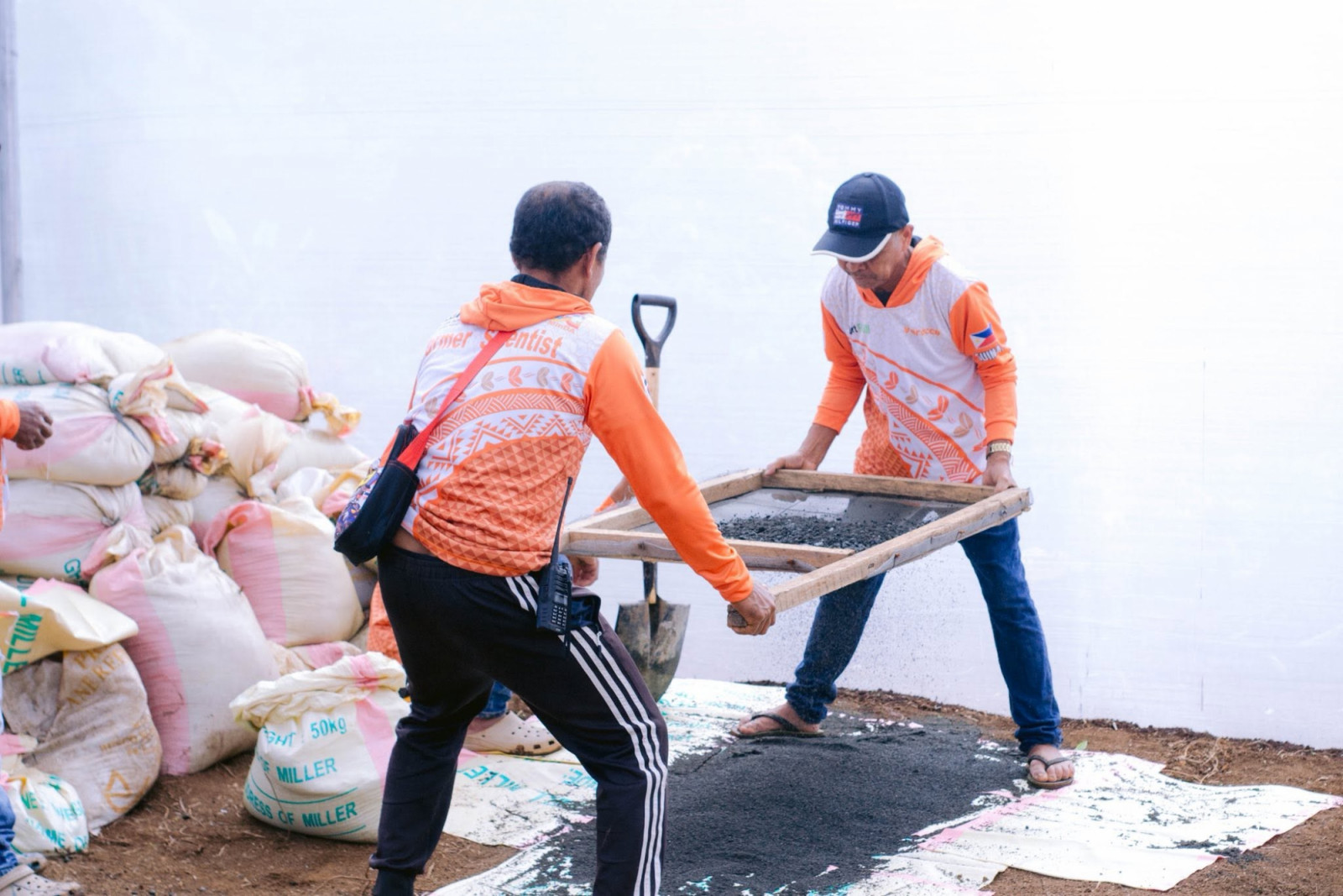Farmers from a 'Farmer Scientist' initiative meticulously sift materials for quality coffee cultivation.