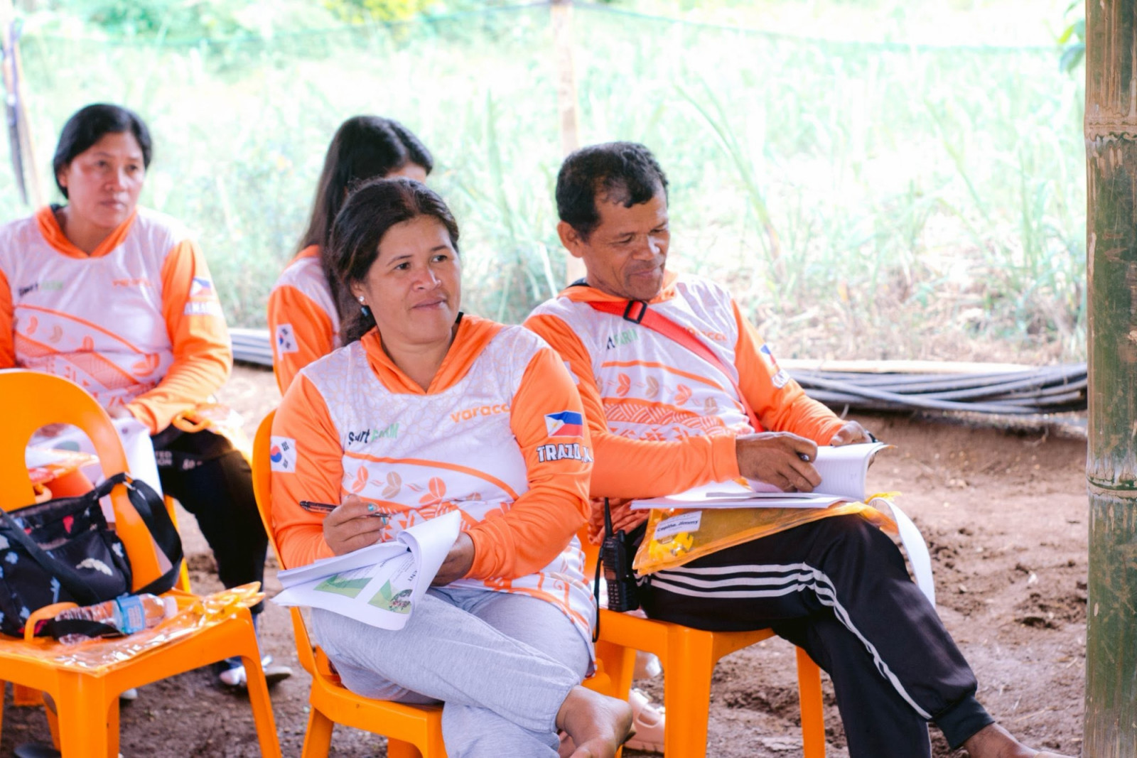 Members of a coffee community initiative, wearing branded shirts with coffee bean motifs, gather for an event.