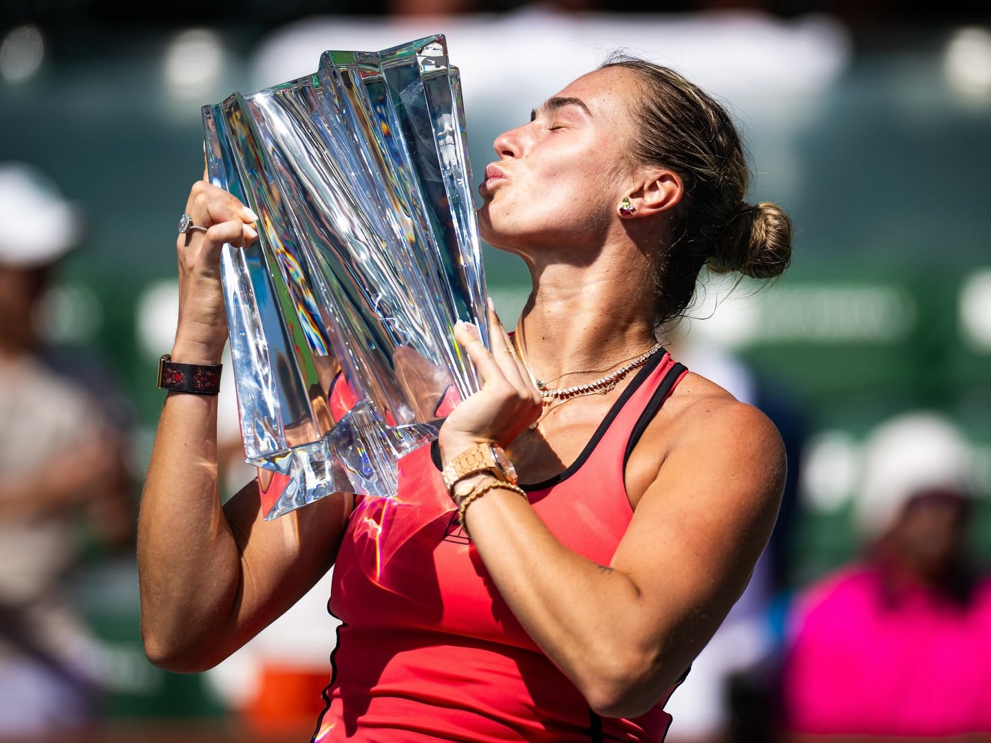 Aryna Sabalenka celebrates her victory, kissing the championship trophy.