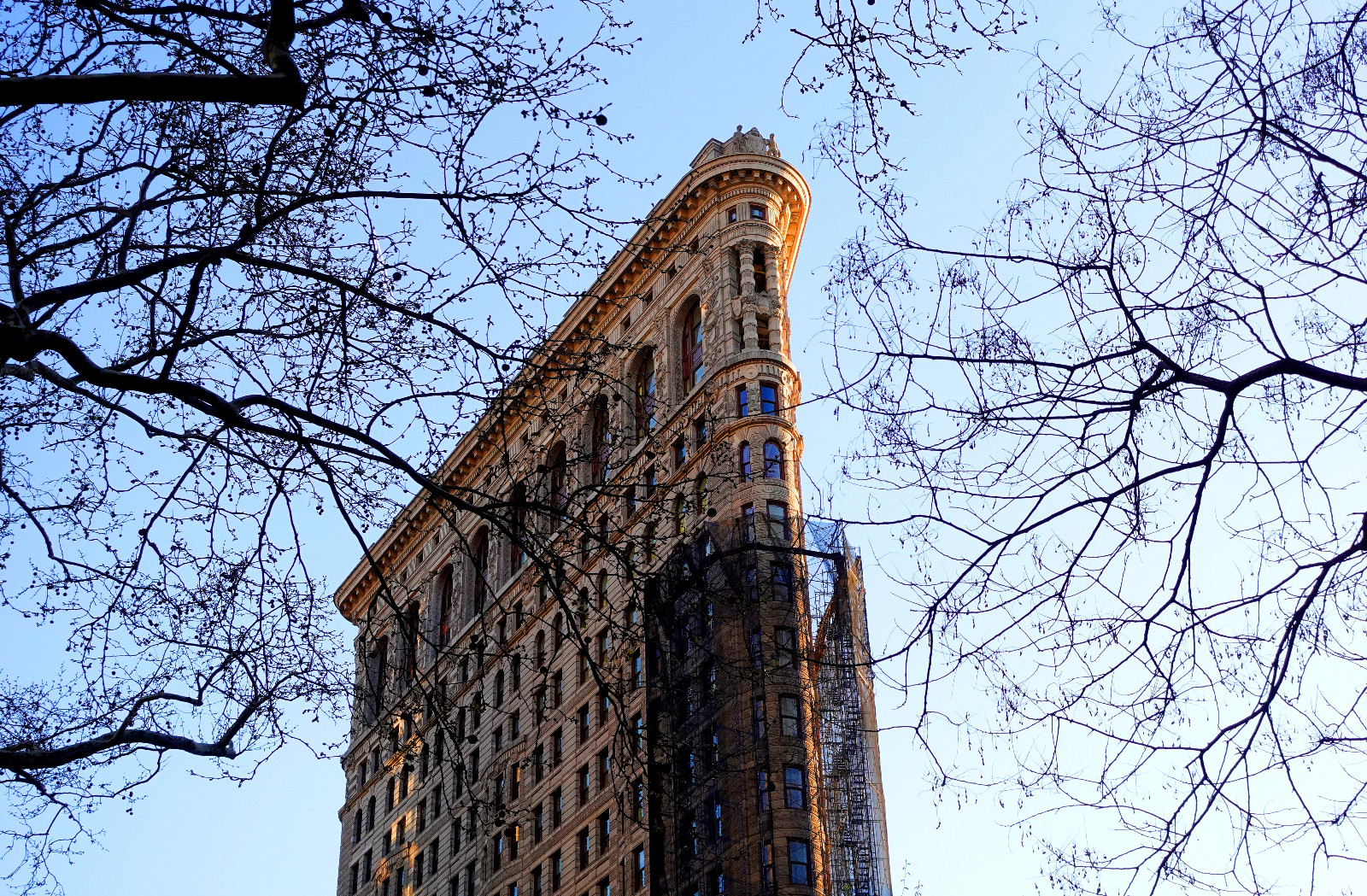 NEW YORK, NY - APRIL 8: The sun sets on the Flatiron Building as scaffolding and netting that has shrouded the facade for seven years during an office-to-residential conversion begins to be removed, on April 8, 2026, in New York City. (Photo by Gary Hershorn/Getty Images)