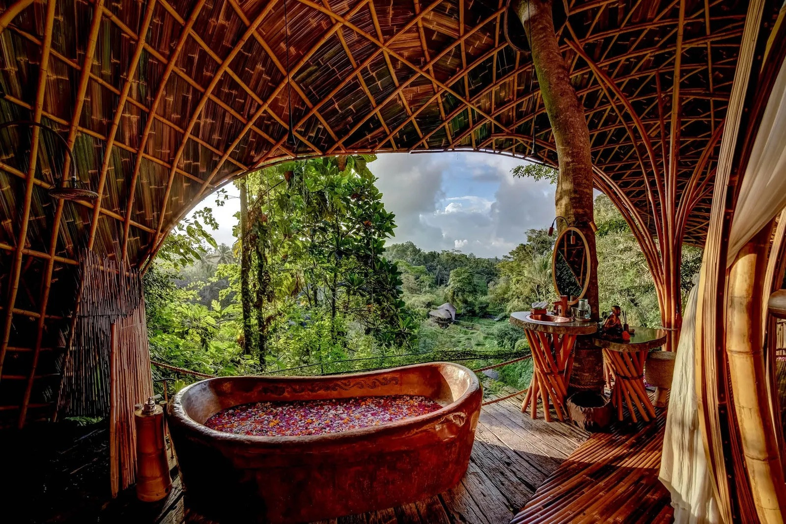 A rose-petal bath inside one of Bambu Indah’s open-air bamboo suites, overlooking the rice terraces below (Photo: Bambu Indah)