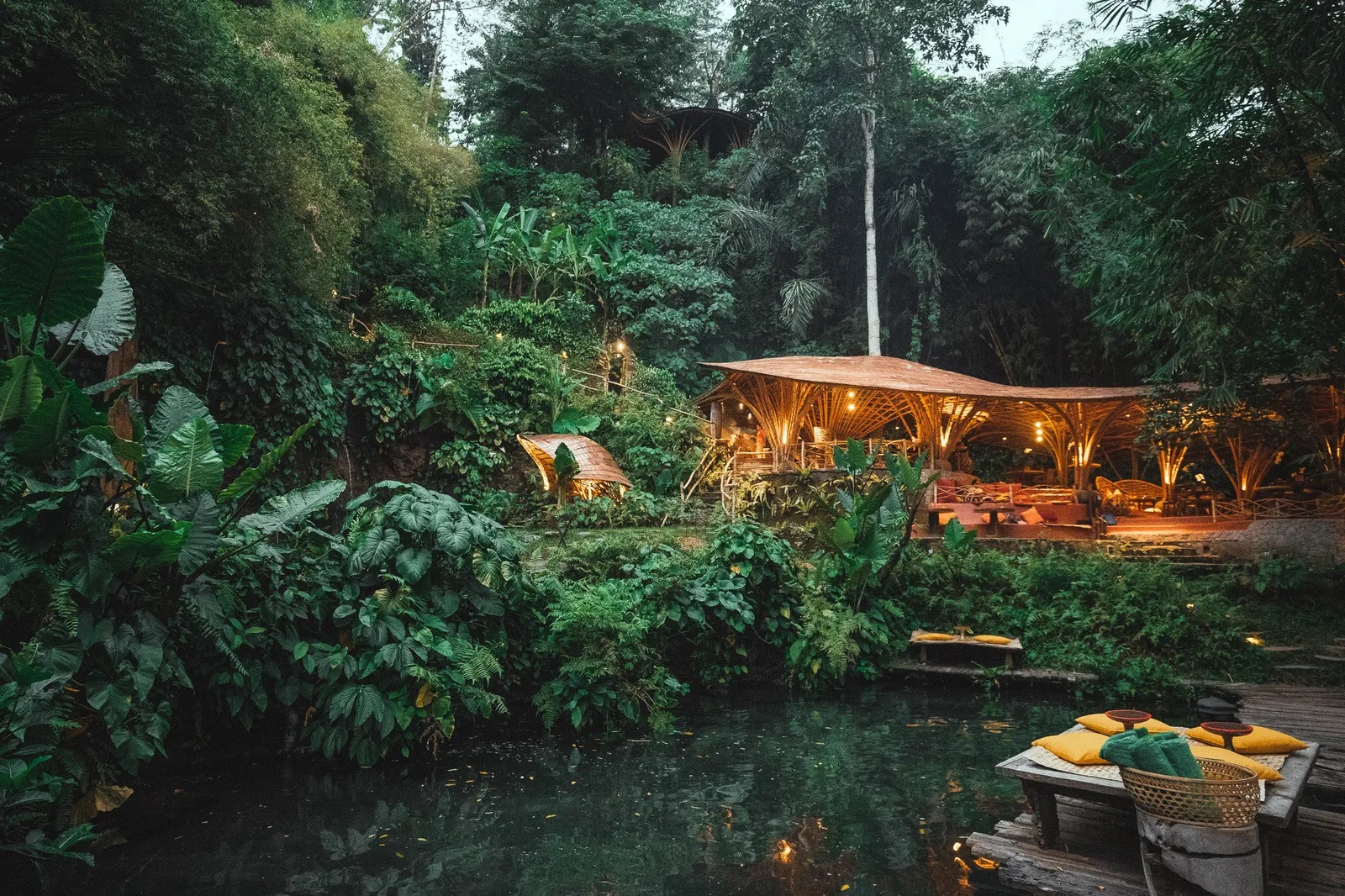 Bambu Indah’s riverside restaurant at dusk, built above the Ayung River’s spring-fed pools (Photo: Bambu Indah)