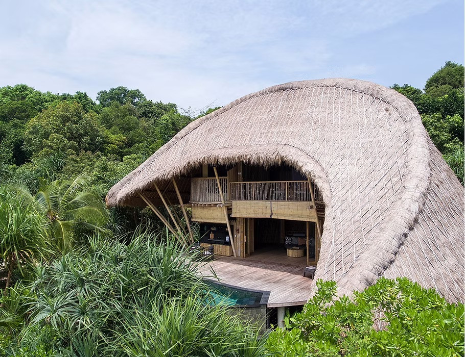 One of Cempedak Island’s bamboo villas seen from above, its thatched roof sweeping open to a private pool and jungle-facing deck