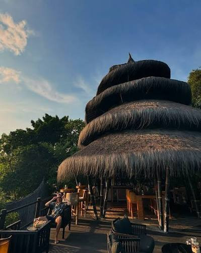 The Dodo Bar at Cempedak Island at sunset, its tiered roof modelled on a cone seashell and thatched in ijuk, a black palm fibre traditionally reserved for Indonesian temple roofs
