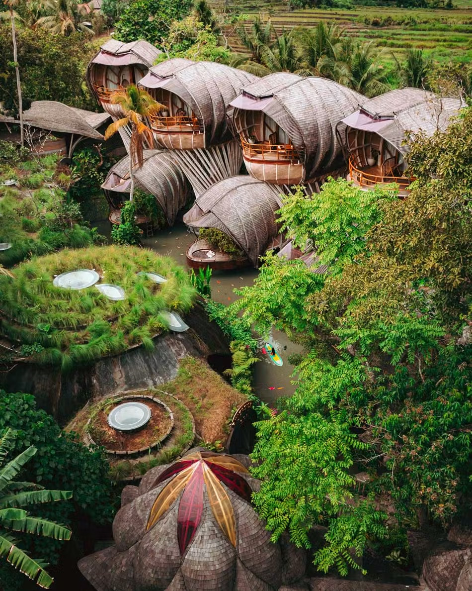An aerial view of Ulaman's cluster of shingled bamboo villas curling above the Bali jungle, each one opening to its own private balcony over the river below