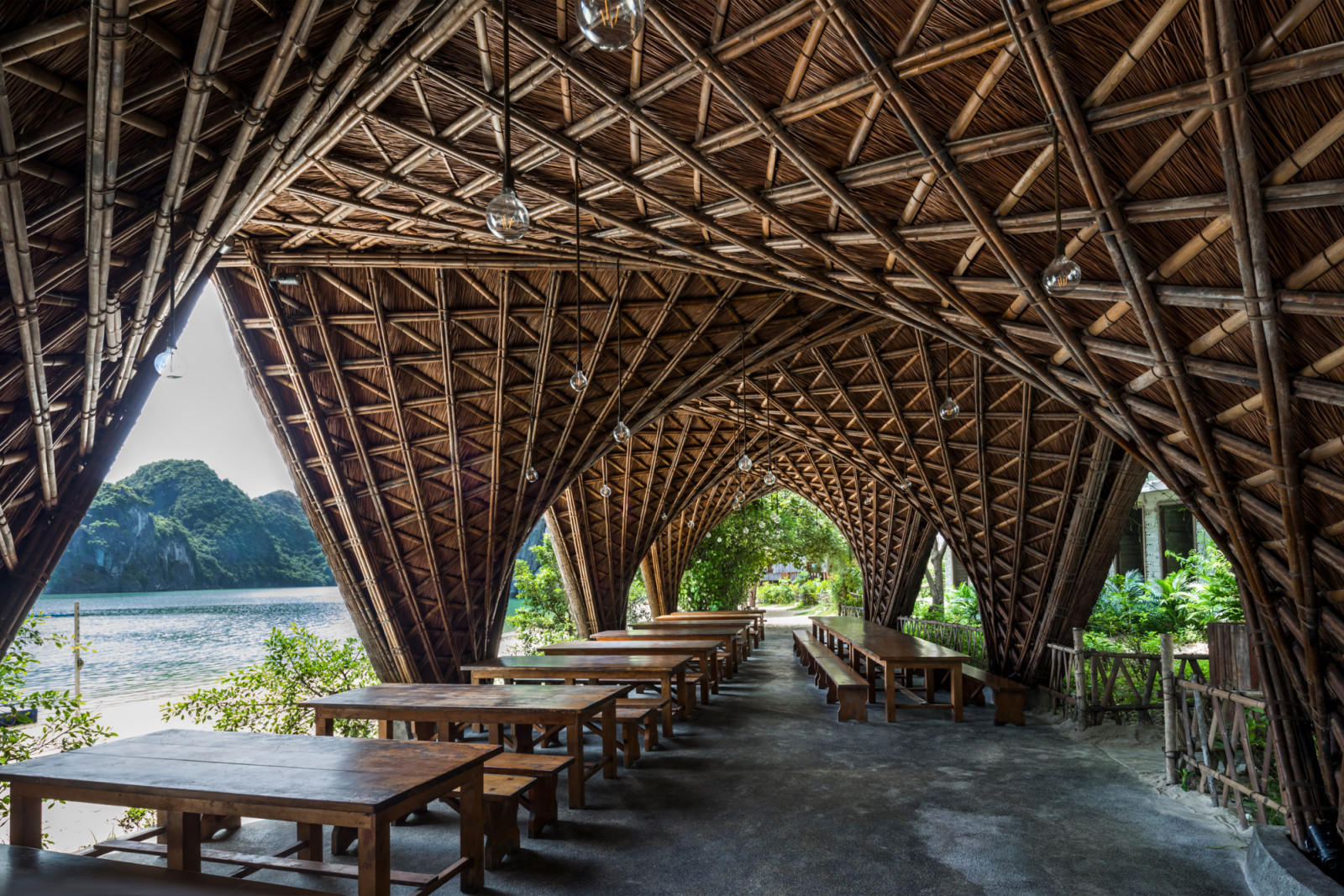 The resort’s restaurant pavilion, with its vaulted bamboo ceiling and criss-crossed trusses, opens onto Lan Ha Bay’s limestone karsts
