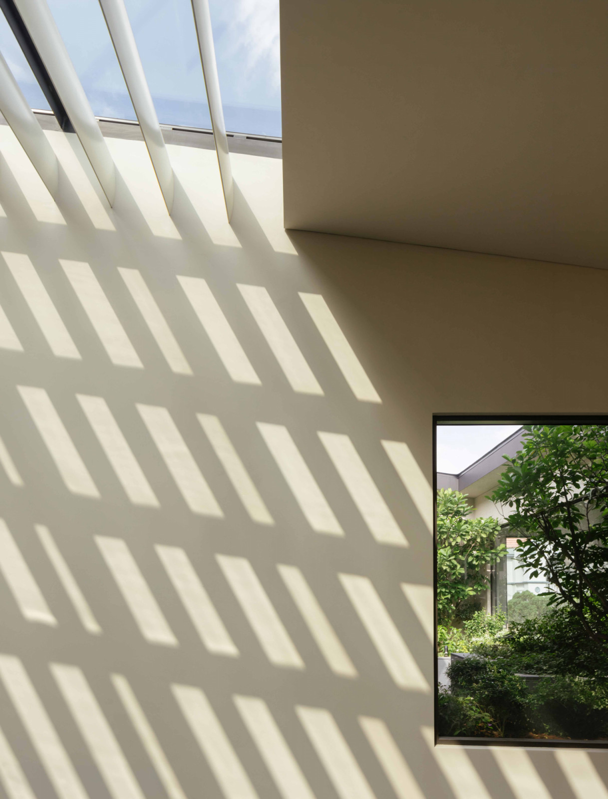Metal fins across the ceiling filter daylight into the family lounge, keeping the atrium "flush with daylight" as the patterns shift through the day