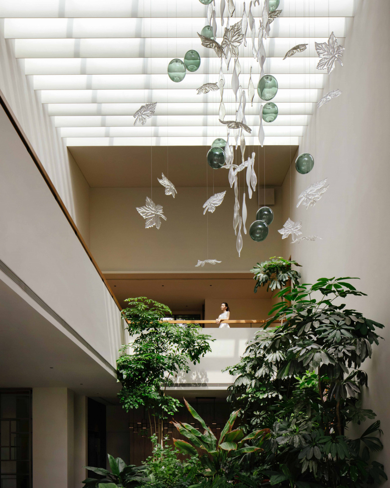 A chandelier of falling crystal leaves cascades through the Good Class Bungalow’s atrium, continuing the home’s botanical narrative