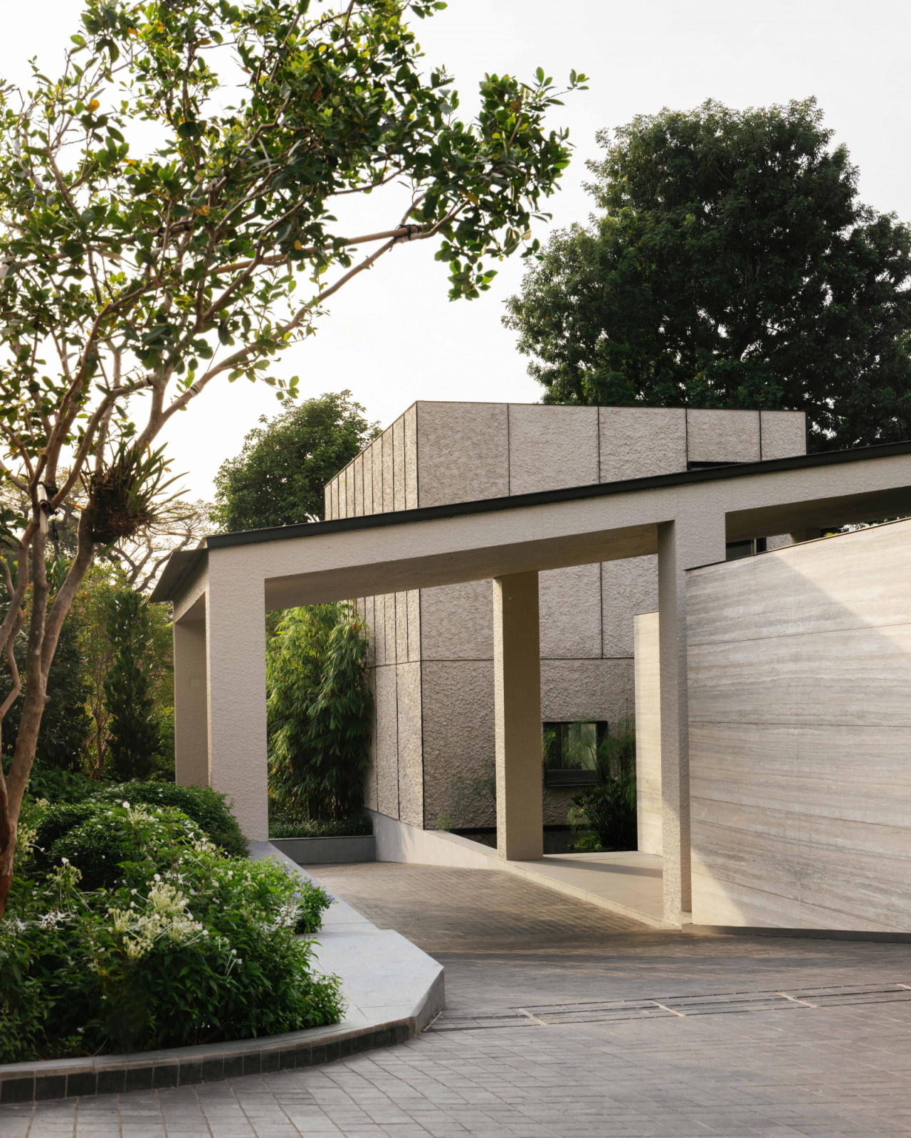 The entrance pavilion's palette of beige roughcast plaster and honed travertine helps “reveal the colour of the garden, and register light and shadow with the passing clouds,” says the architect