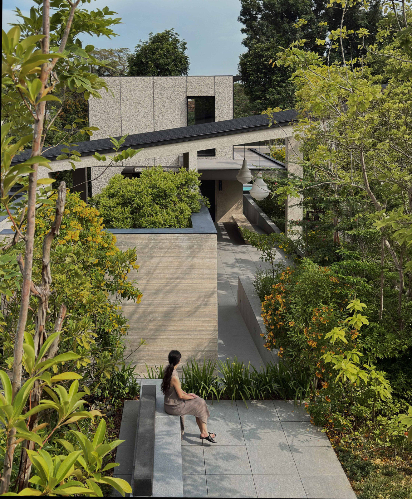 A sheltered pathway on the outer ring links the pavilions, turning every walk through the house into an alternation of light and shade