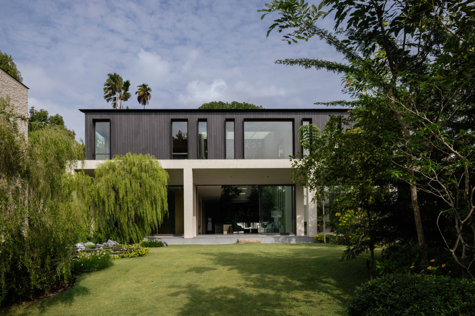 The master pavilion’s contrasting dark timber and light travertine volumes command the highest point of the site