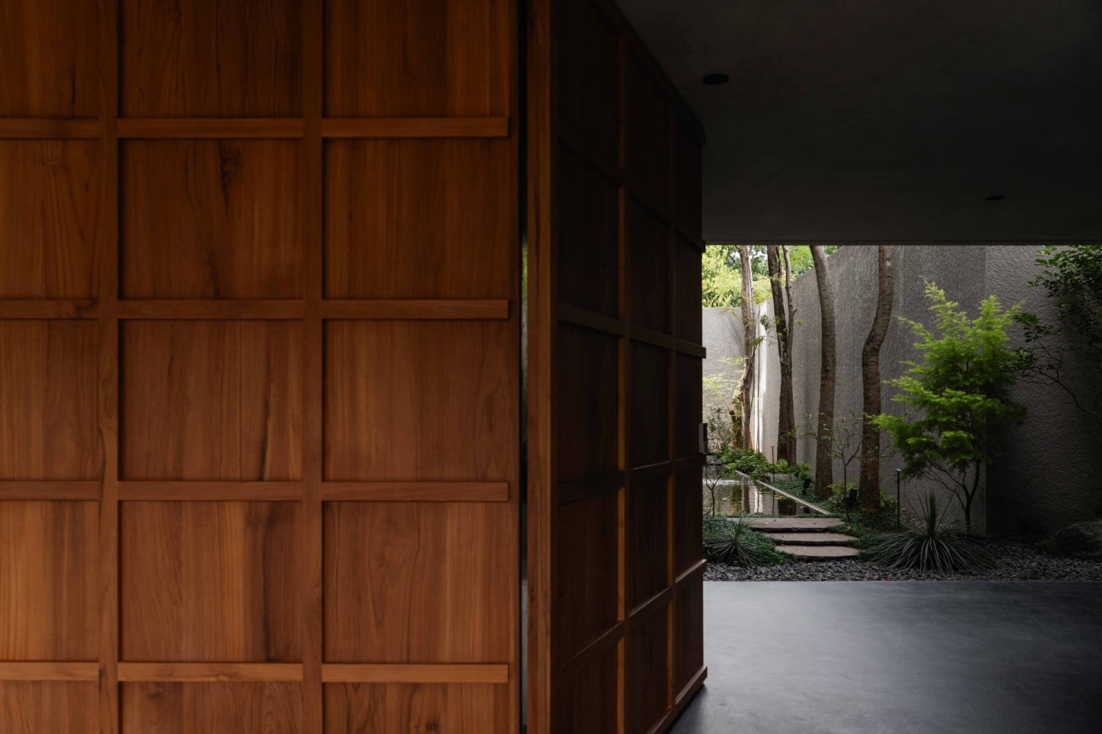 Timber doors mark the transition from the carport to the side garden