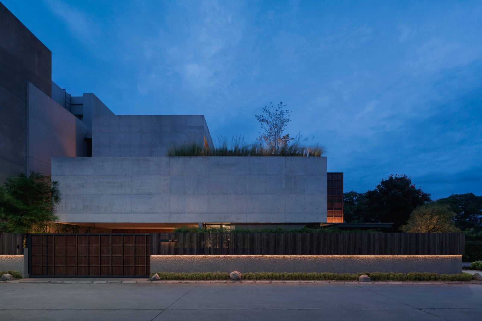 Lift House presents a closed, near-windowless face to the street, its privacy deliberate in Bandung