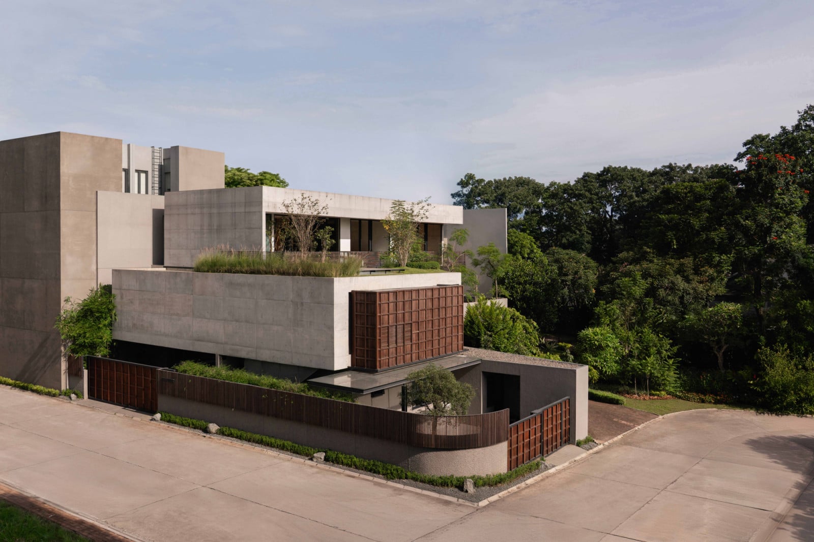 An aerial view showing how the concrete volumes step back on each level and the rooftop garden bridges the second storey and the timber-screened structure below