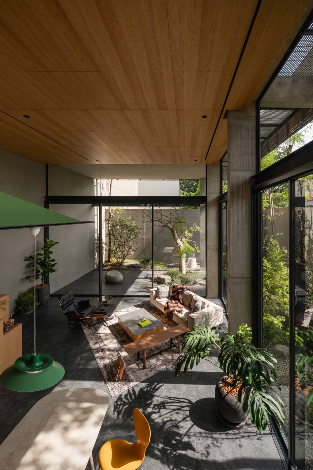 Floor-to-ceiling glazing lets the living room borrow its garden's greenery from almost every angle