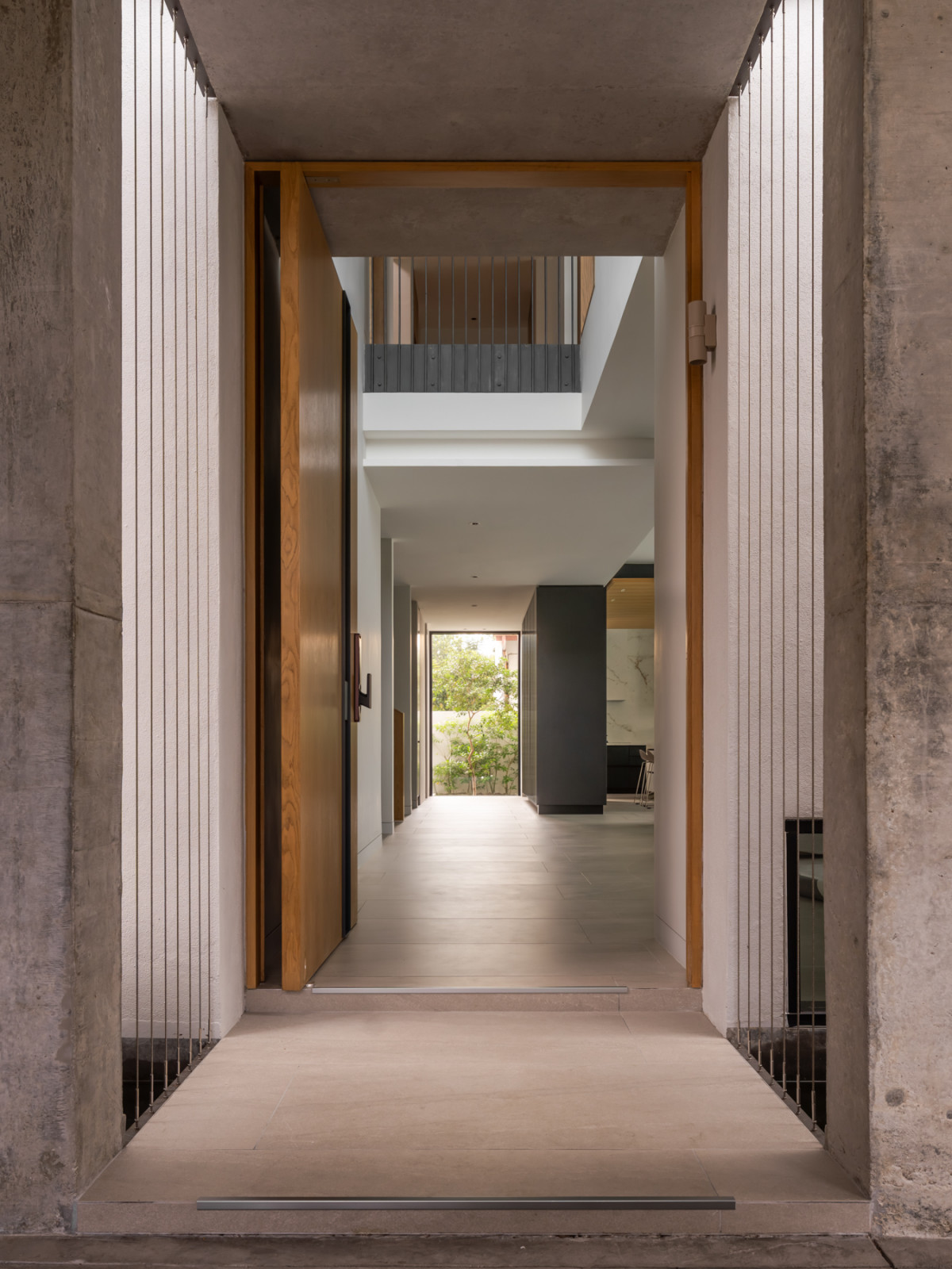 The entrance hall leads directly through to the kitchen, with a courtyard tree visible partway down the corridor