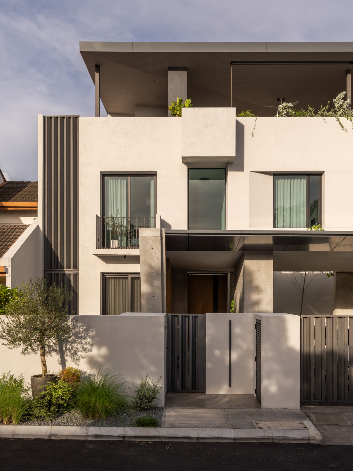 A closer view of the entrance shows the timber front door beneath the cantilevered upper floor