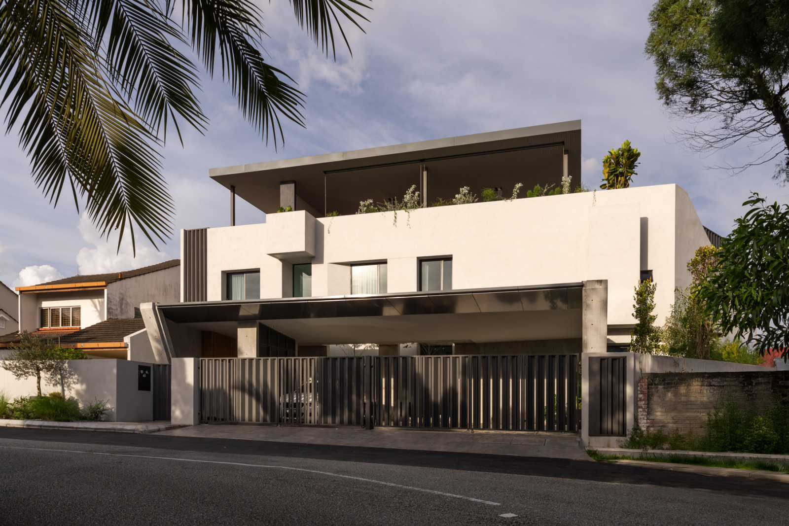 The front elevation shows the car porch beneath a cantilevered upper floor, with the roof terrace’s open structure visible above