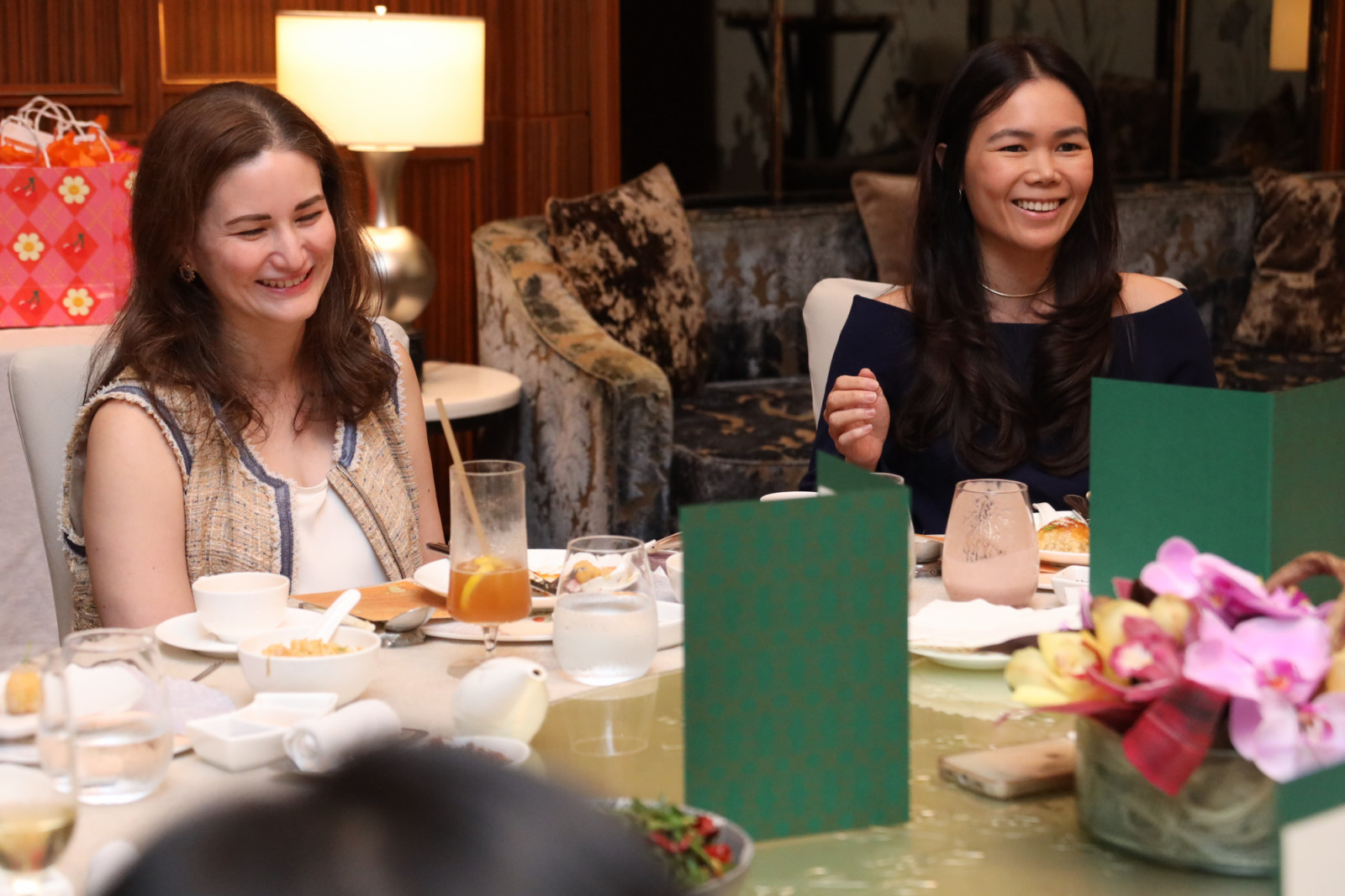 Guests enjoy a moment of shared laughter during a lively dining event.
