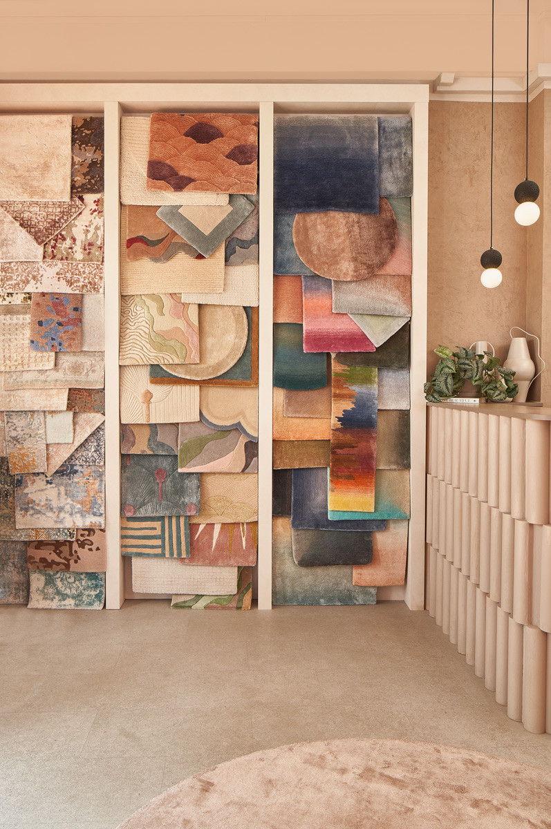 A swatch-lined wall with a curio cabinet and reading chair at the Living DNA Joo Chiat showroom