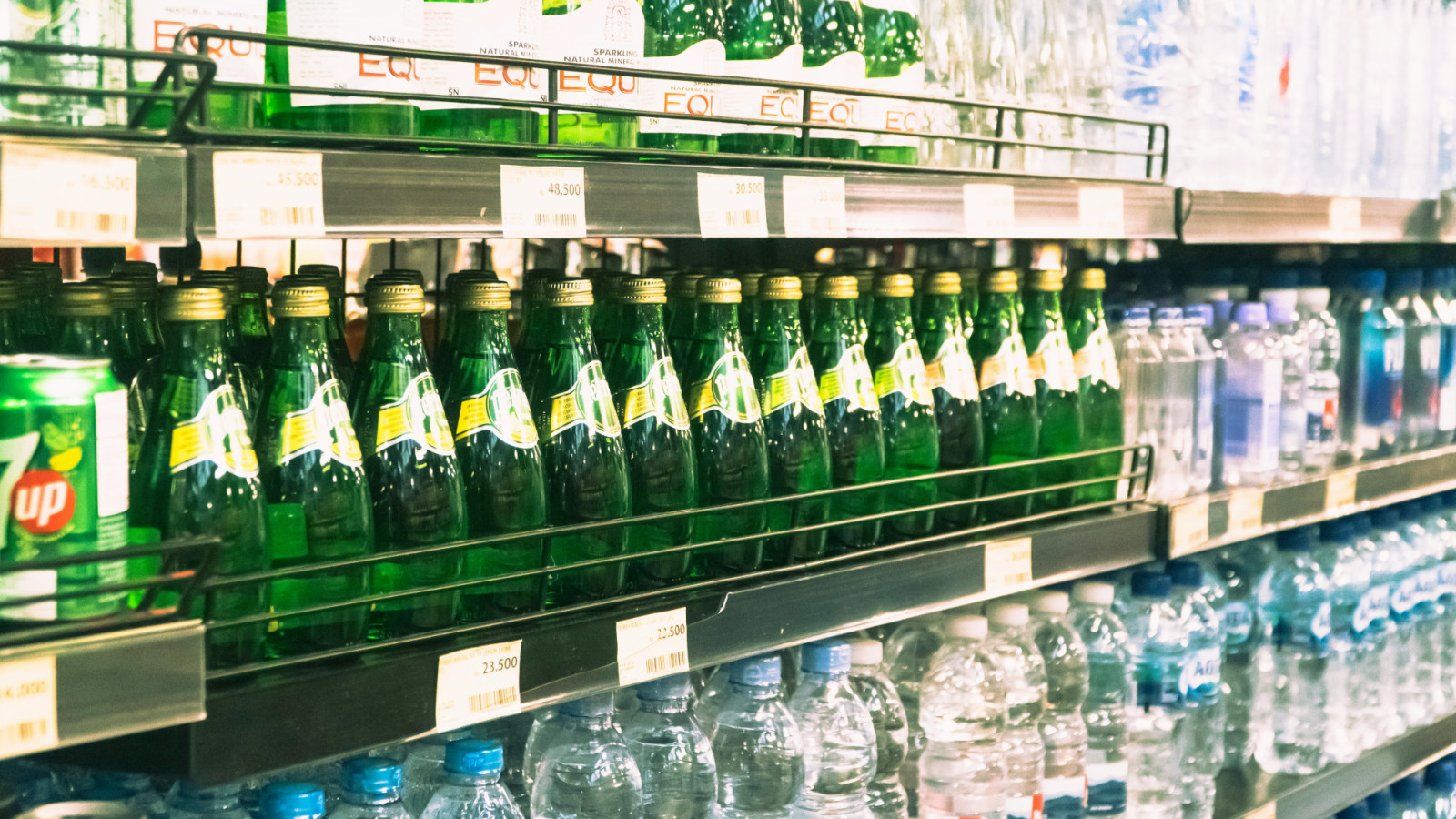 Perrier and Equil sparkling mineral waters, alongside other bottled varieties, line a retail shelf.