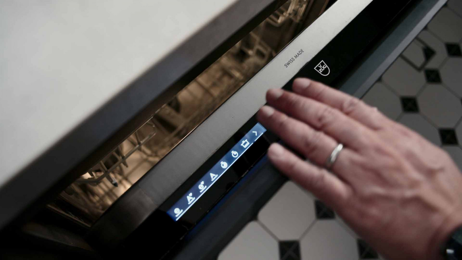 A close-up of the V-ZUG dishwasher's Swiss Made insignia