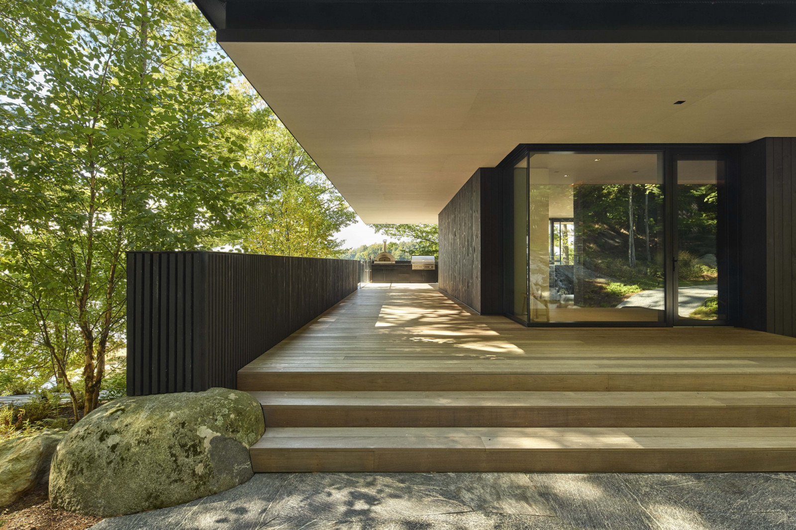 Vertical planes form walls and guardrails, while horizontal planes extend overhead as an extensive cantilevered roof