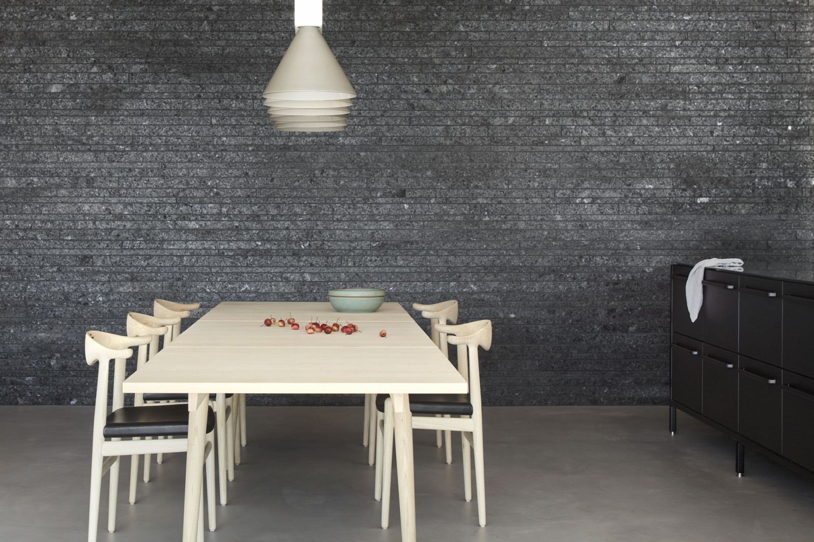The subtle variations in the grouting technique evokes the layered striations of natural rock formations