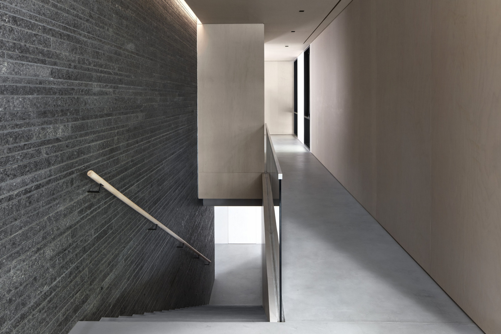 The black granite feature wall establishes a strong, monolithic presence throughout the home