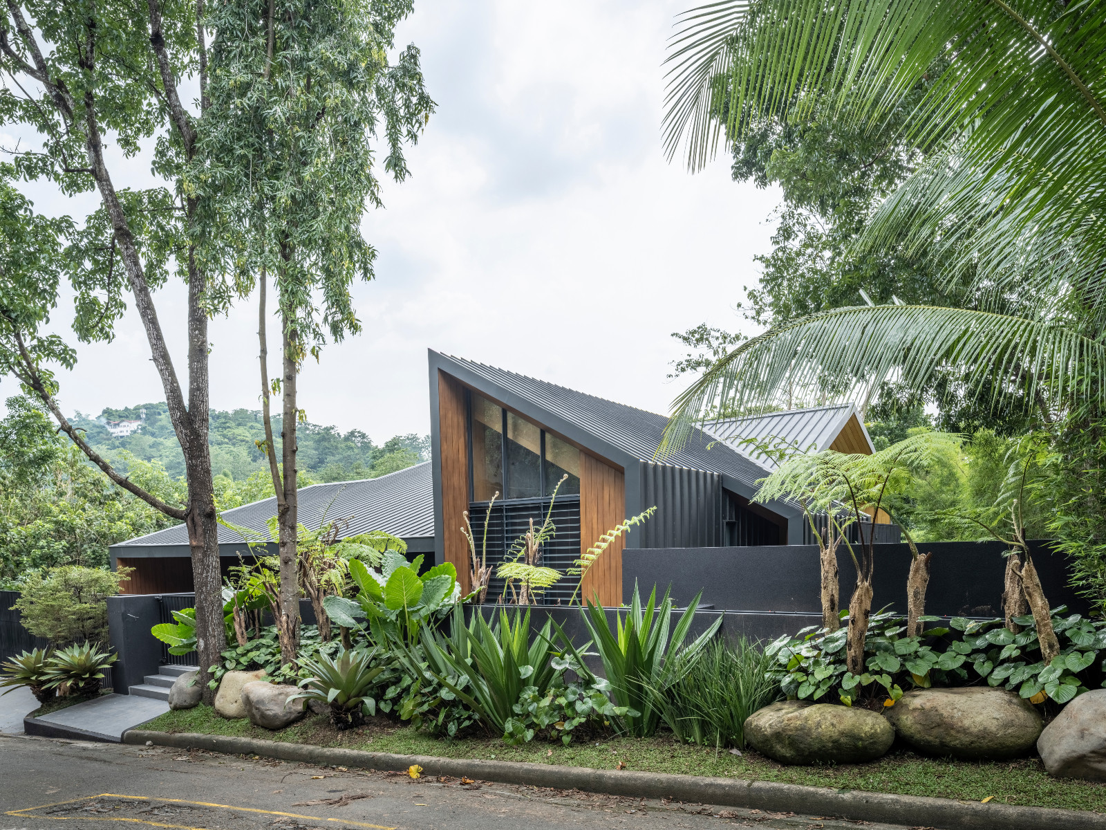 Seen from the outside, the home’s sculptural roofline emerges discreetly from dense tropical gardens, revealing little of the generous spaces within