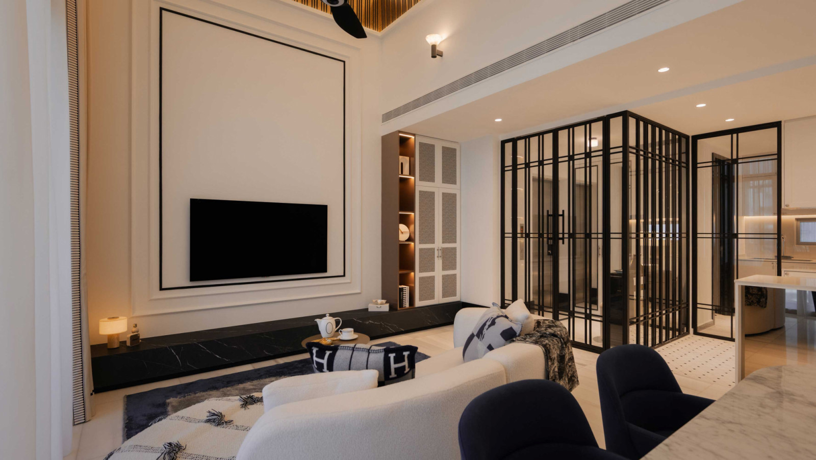 The crisp lines of the black-framed vestibule in this penthouse by K2SD Group stand out in the light-filled living area