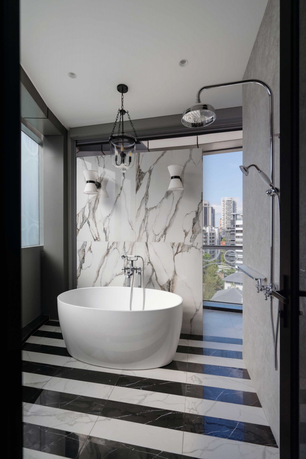 A view of the chic master bathroom, which flaunts its art deco design inspirations through symmetrical vignettes, stepped forms and a high-contrast colour scheme