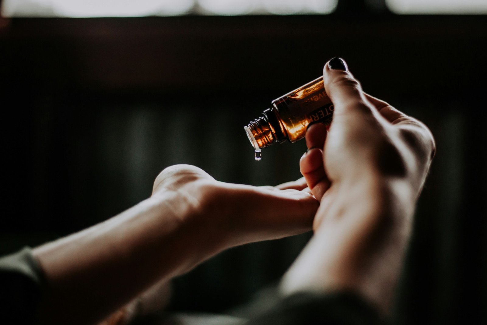 A drop of skincare product is dispensed into a hand, reflecting a moment of mindful self-care.
