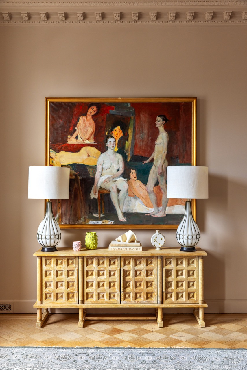 In the Primary Bedroom, vintage Murano lamps from Hedge flank a figurative painting above a Honore console by Athena Calderone for Crate & Barrel