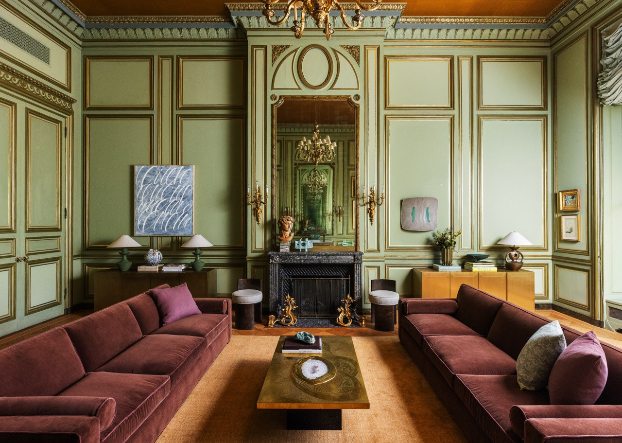 A gilt mirror doubles the reflection of a crystal chandelier in one of the mansion’s green-paneled rooms.