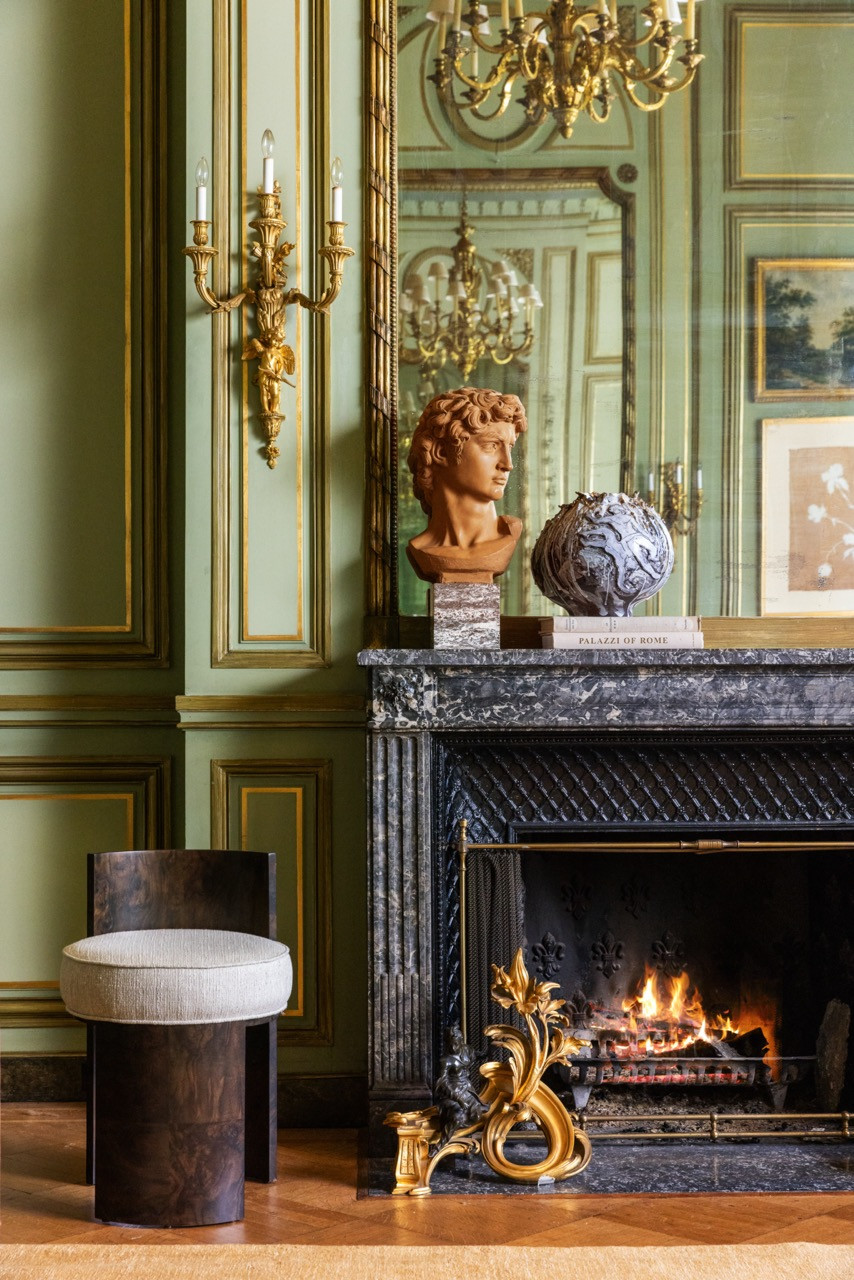 A terracotta bust and a carved marble orb rest on the mantel of the Green Ballroom's black marble fireplace