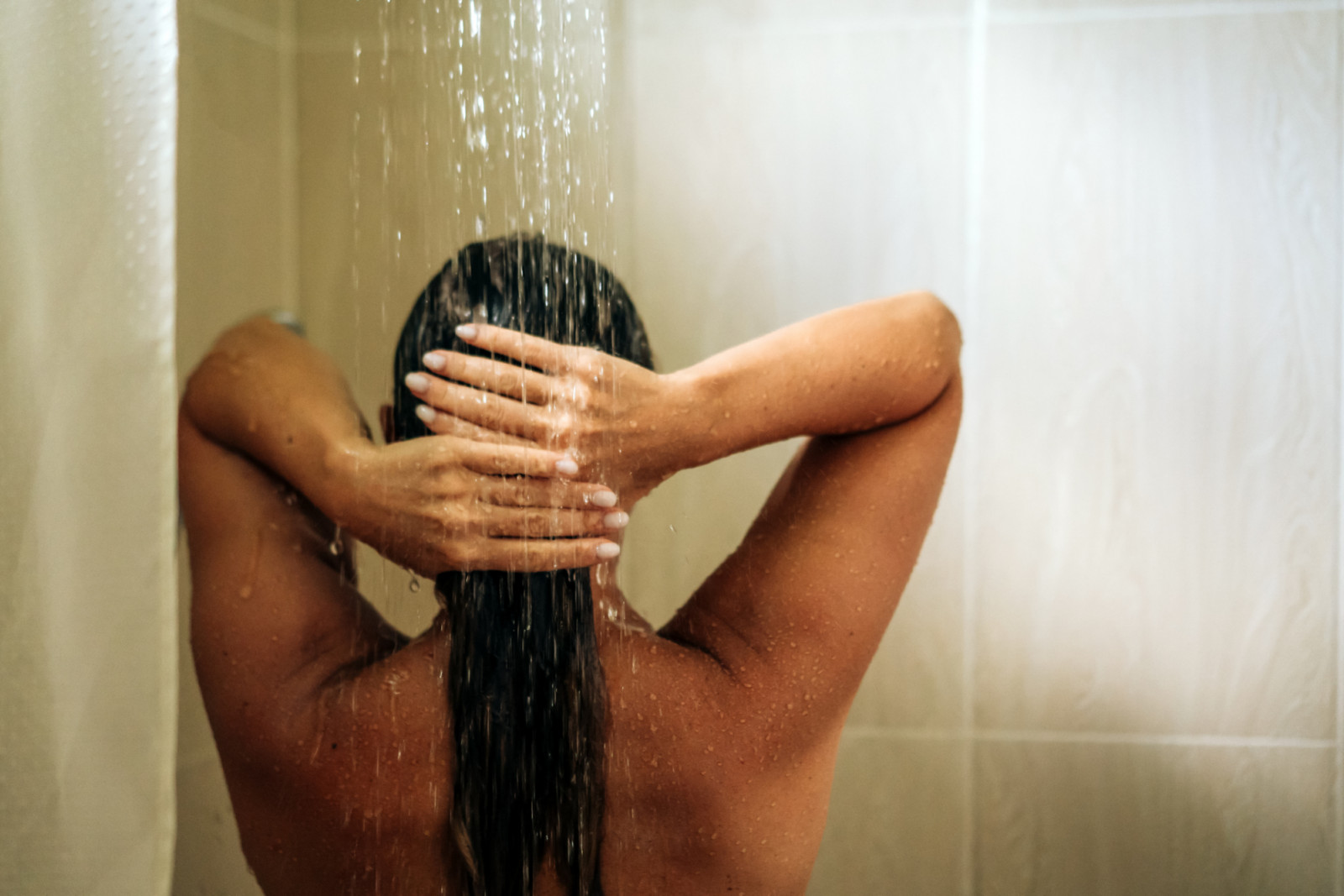 Woman in the hotel room having a shower. Vacation in the tropical resort, morning routine