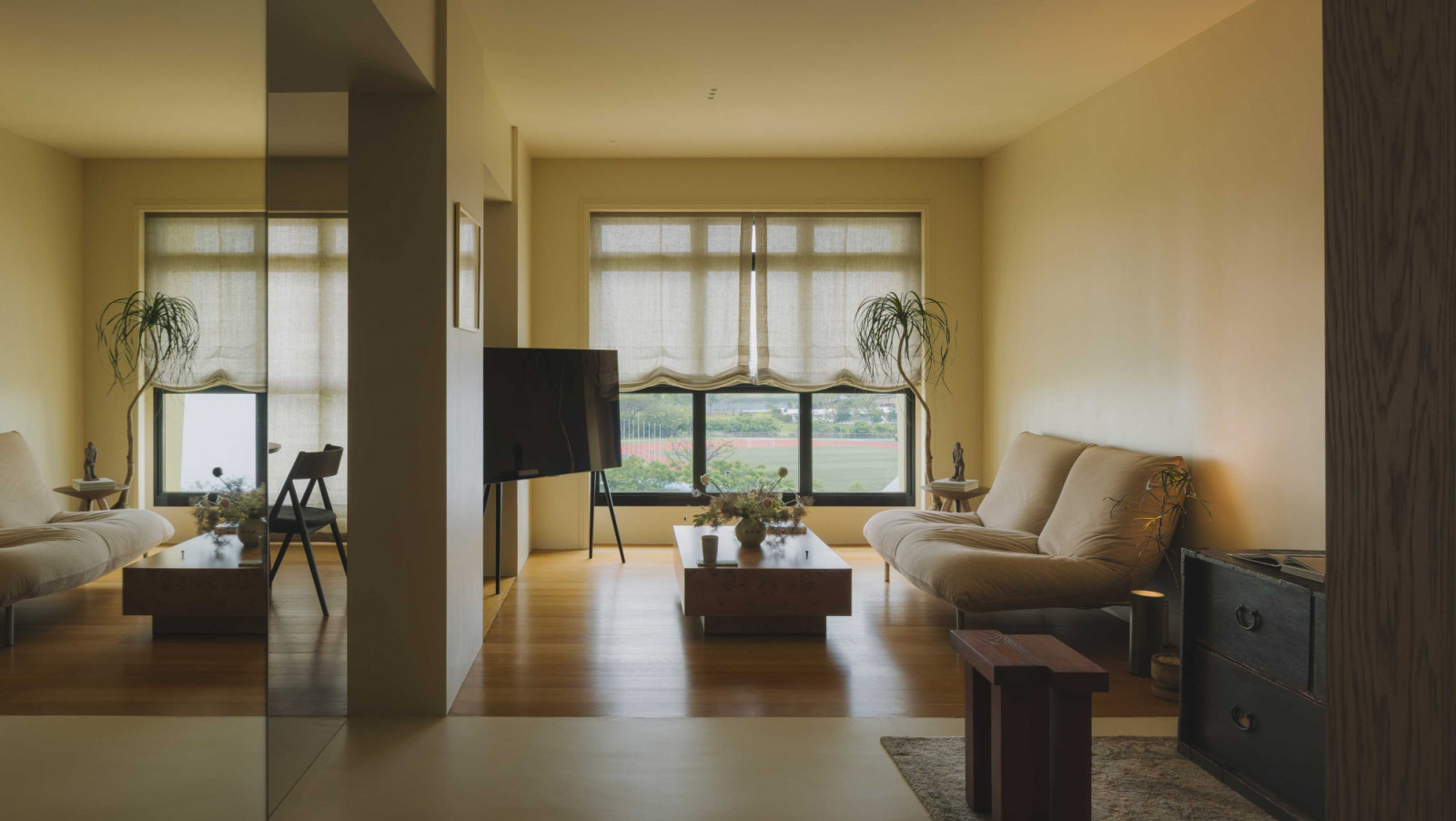 A full-length mirror in this Bud Studio apartment visually expands the foyer while a monolithic column separates the living space from the dining area without adding bulk