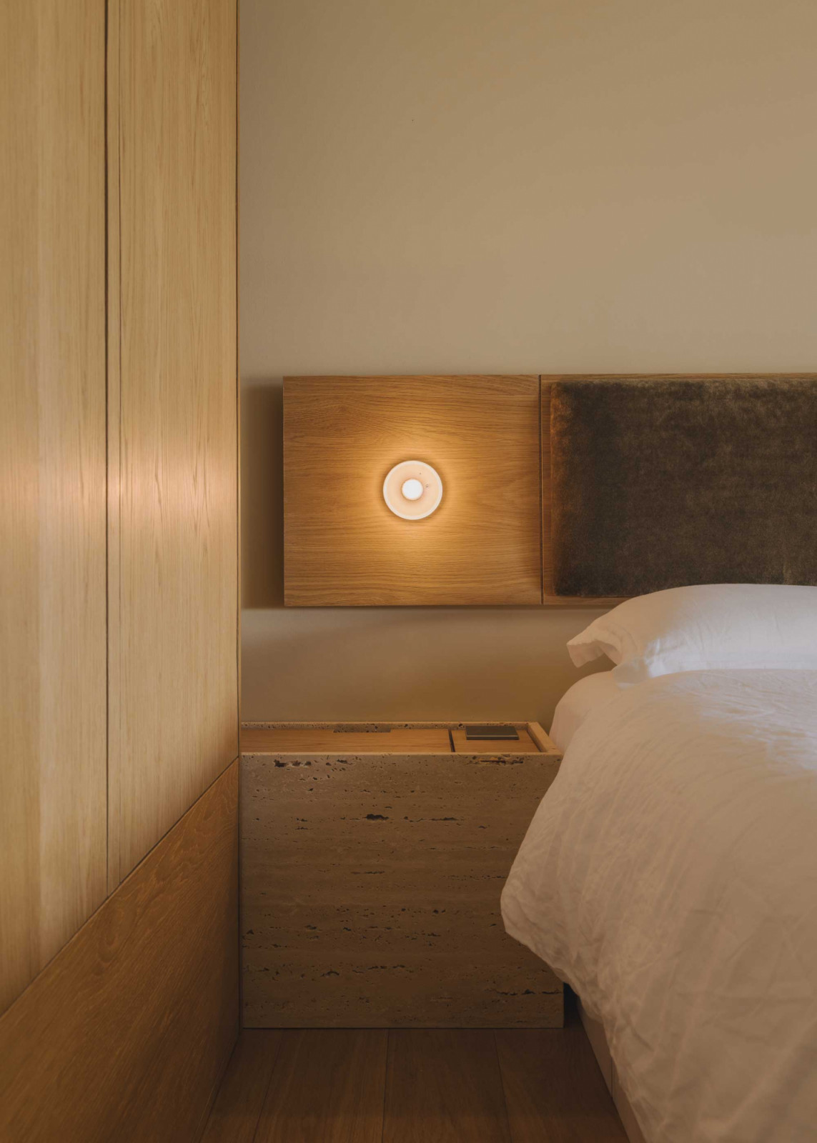 The tactile materials used in this bedroom, such as natural veneer, stone and engineered timber, invite one to touch and interact constantly
