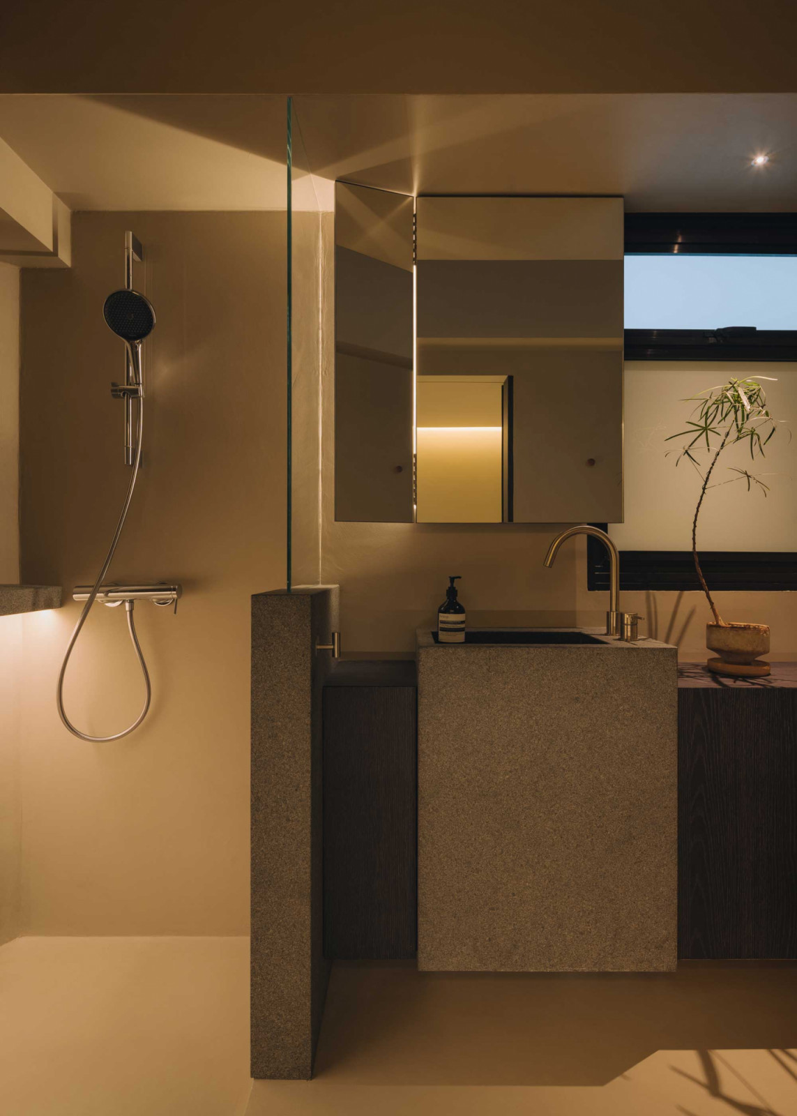 A block-like stone sink commands attention in this bathroom
