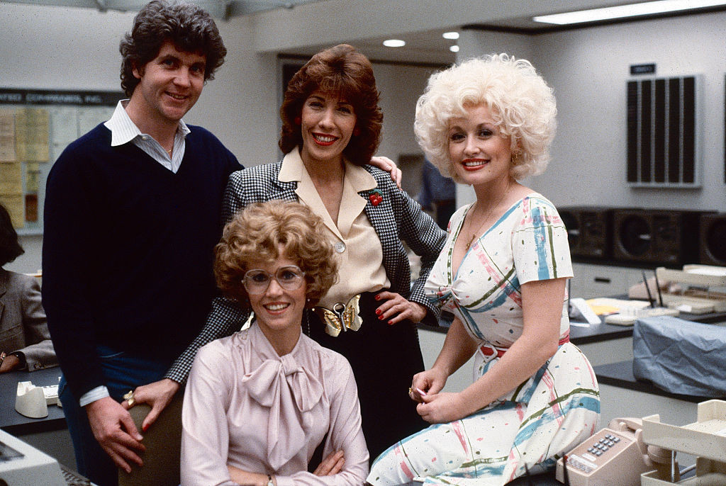 Portrait of, from left, Australian-American film director Colin Higgins (1941 - 1988), and American actors Jane Fonda (fore), Lily Tomlin (in checked blazer), and Dolly Parton on the set of the film '9 to 5' (also known as 'Nine to Five,' directed Higgins), Los Angeles, California, 1979. (Photo by Steve Schapiro/Corbis via Getty Images)