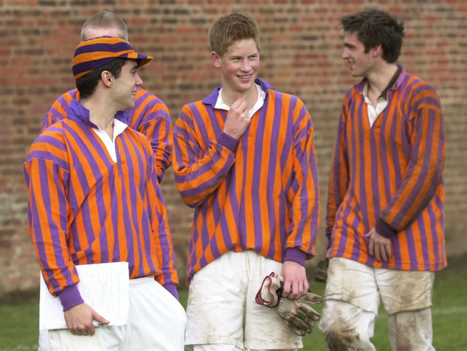 WINDSOR- MARCH: (FILE PHOTO) Prince Harry chats with team mates when he participates in the Wall Game between a school team and a team of old boys at Eton College in March 2003 in Windsor, England. (Photo by Anwar Hussein/Getty Images)