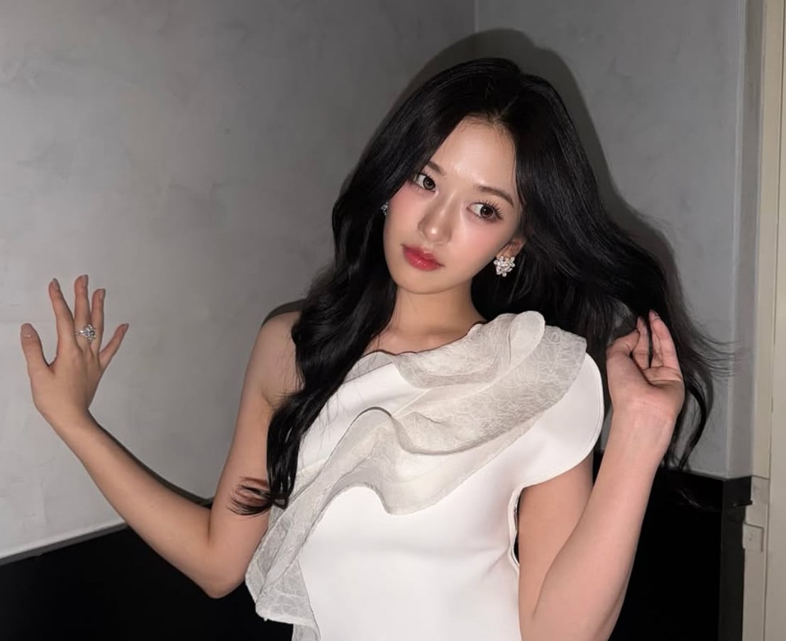 An Yu-jin, leader of K-pop group IVE, exudes sophistication in a white one-shoulder dress with ruffled detail.
