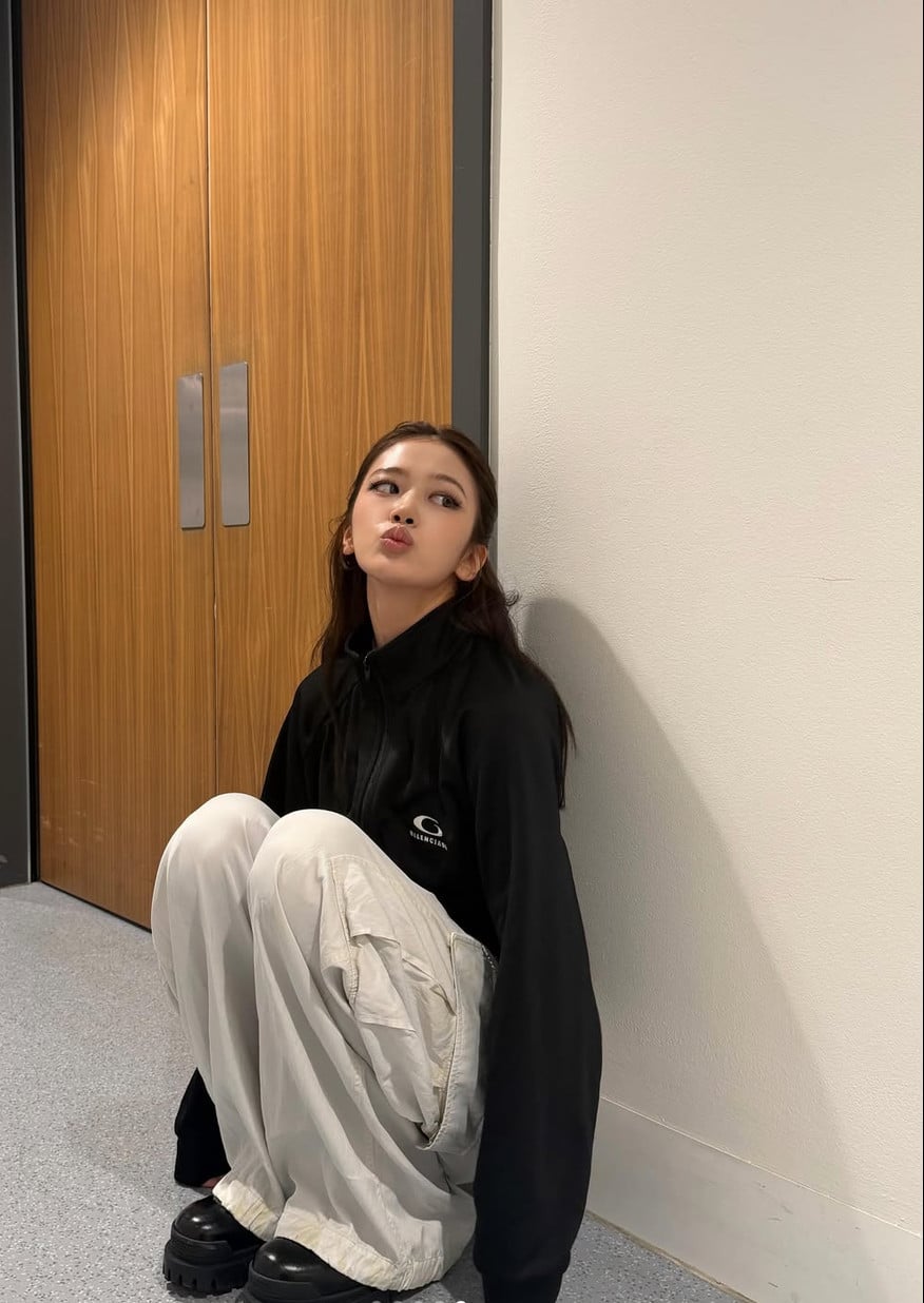An Yujin wears a black Balenciaga track jacket paired with light cargo pants, reflecting her signature style.